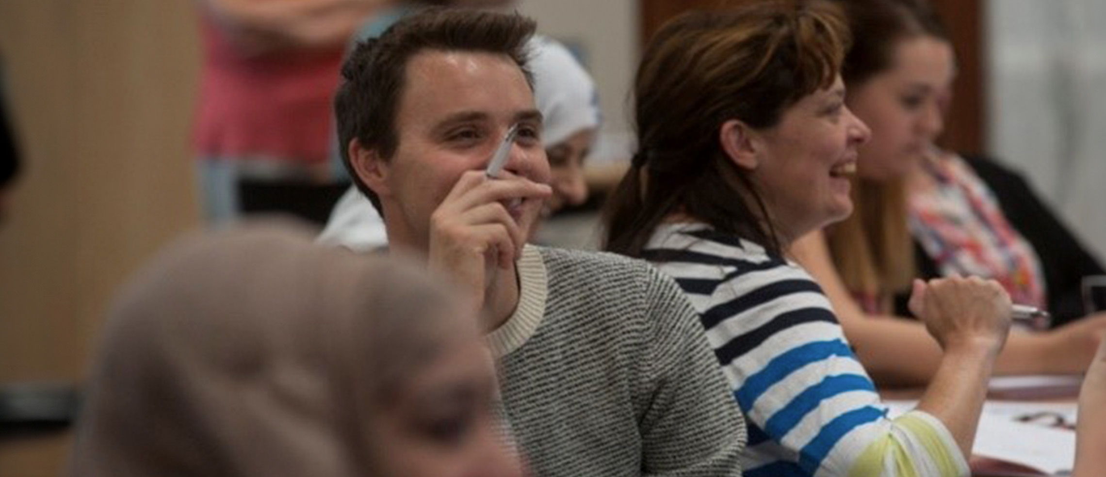 A young male teacher listening to a speech