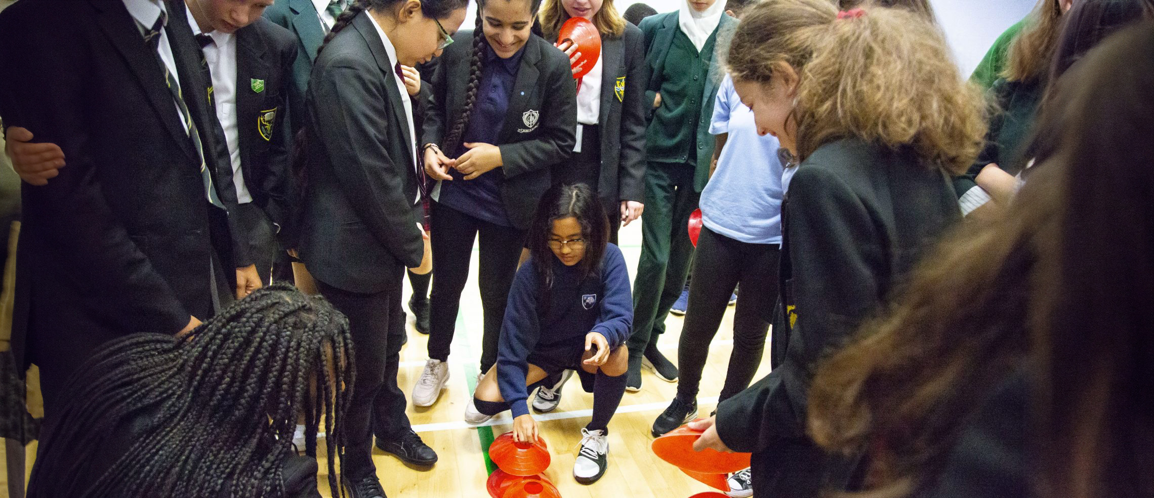 A group of children gather around as they perform an activity